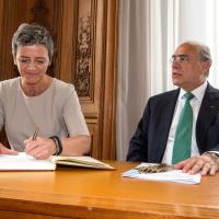 Margrethe Vestager signing the guest book of the OECD, in the presence of Angel Gurría