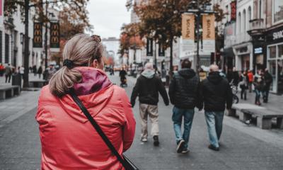 Woman in the front, people walking in Antwerp